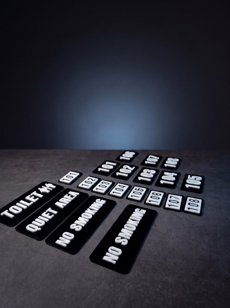 Custom black and white room numbers and facility labels