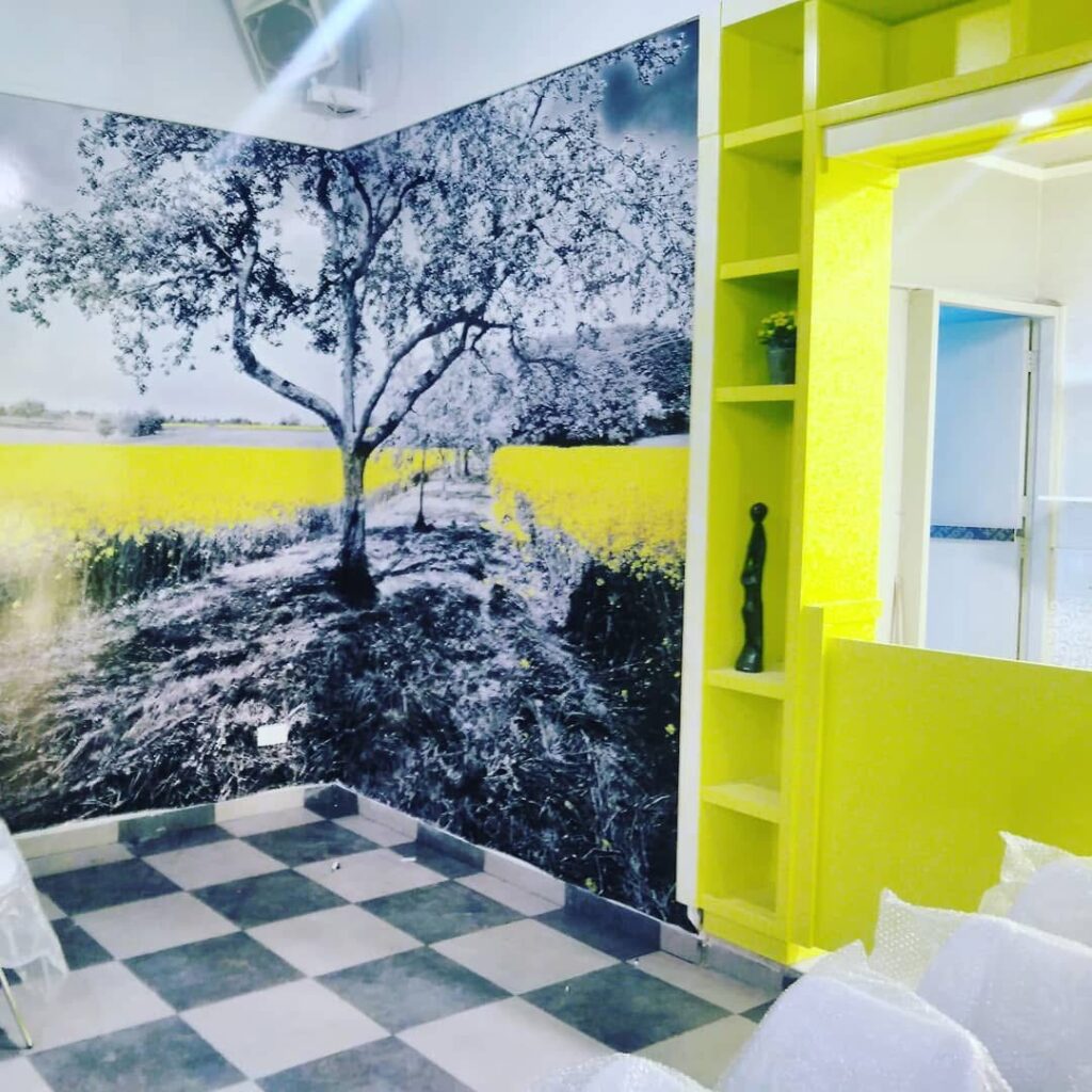 Tree landscape wallpaper installed beside lime-green shelving.