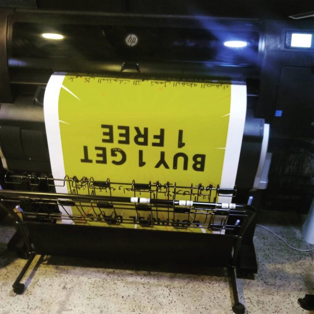Large-format printer producing a yellow promotional poster.