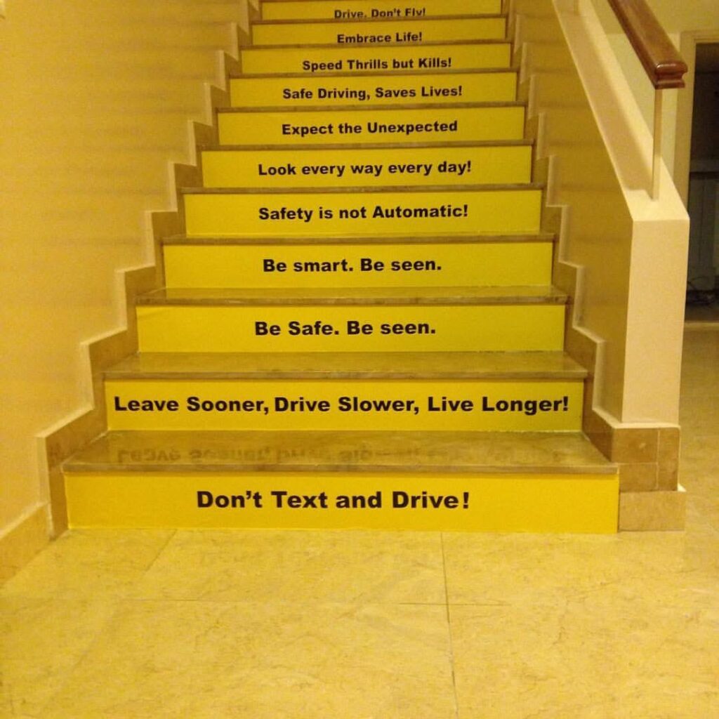 Yellow stair-riser graphics displaying road-safety messages.
