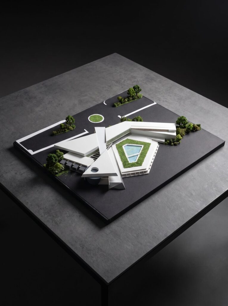 Angular architectural site model arranged around a central green courtyard.