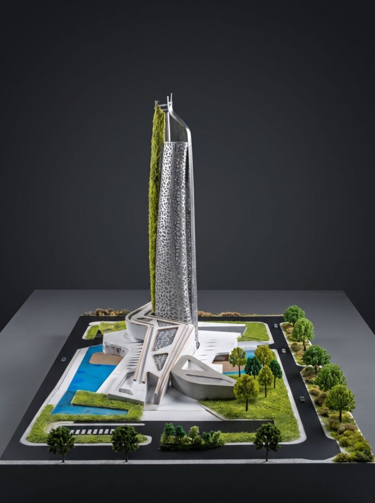 Tall tower scale model with landscaped grounds and a blue pool.